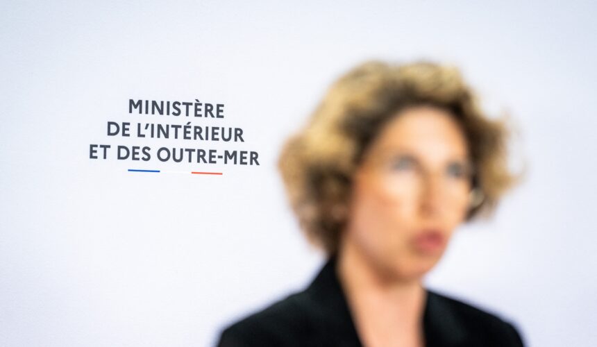 Paris le 16 avril 2024. Photographie par Xose Bouzas / Hans Lucas / AFP. Conférence de presse au sujet de la lutte contre l’immigration irrégulière et la délinquance à Mayotte, au ministère de l’Intérieur et des Outre-mer. Près d’un an après le lancement de l’opération Wuambushu, la ministre déléguée chargée des Outre-mer, lance une nouvelle opération d’ampleur pour lutter contre l’immigration irrégulière, la délinquance et l’habitat illégal à Mayotte. Illustration du logo du ministère de l’Interieur et des Outre mer lors de la prise de parole de Marie Guevenoux, ministre déléguée auprès du ministre de l’Interieur et des Outre-mer, chargée des Outre-mer, floue au premier plan.