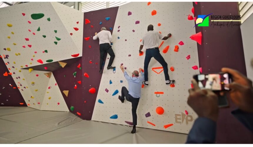 Ce mercredi 9 juillet 2025, de gauche à droite, le recteur Gabriele Fioni, le préfet Xavier Lefort, le président de Région Ary Chalus, se prêtent à tester le mur d’escalade d’un des gymnases inaugurés au sein du lycée Baimbridge. Photo : capture écran vidéo Région Guadeloupe.