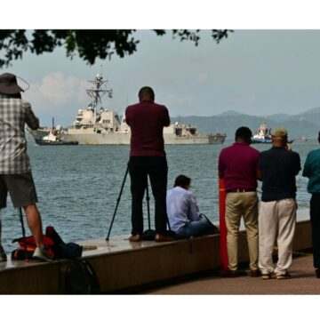 Le public prend des photos de l'USS Gravely, un navire de guerre américain, quittant le port de Port of spain le 30 octobre 2025. Le navire de guerre américain était arrivé à Trinidad-and-Tobago le 26 octobre 2025 pour des exercices conjoints au large du Venezuela, alors que Washington intensifiait sa pression contre les trafiquants de drogue et le dirigeant vénézuélien Nicolas Maduro. Photo : Martin Bernetti / AFP